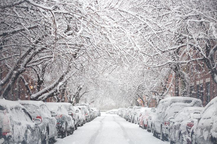 snowy philadelphia street with snow covered cars and trees