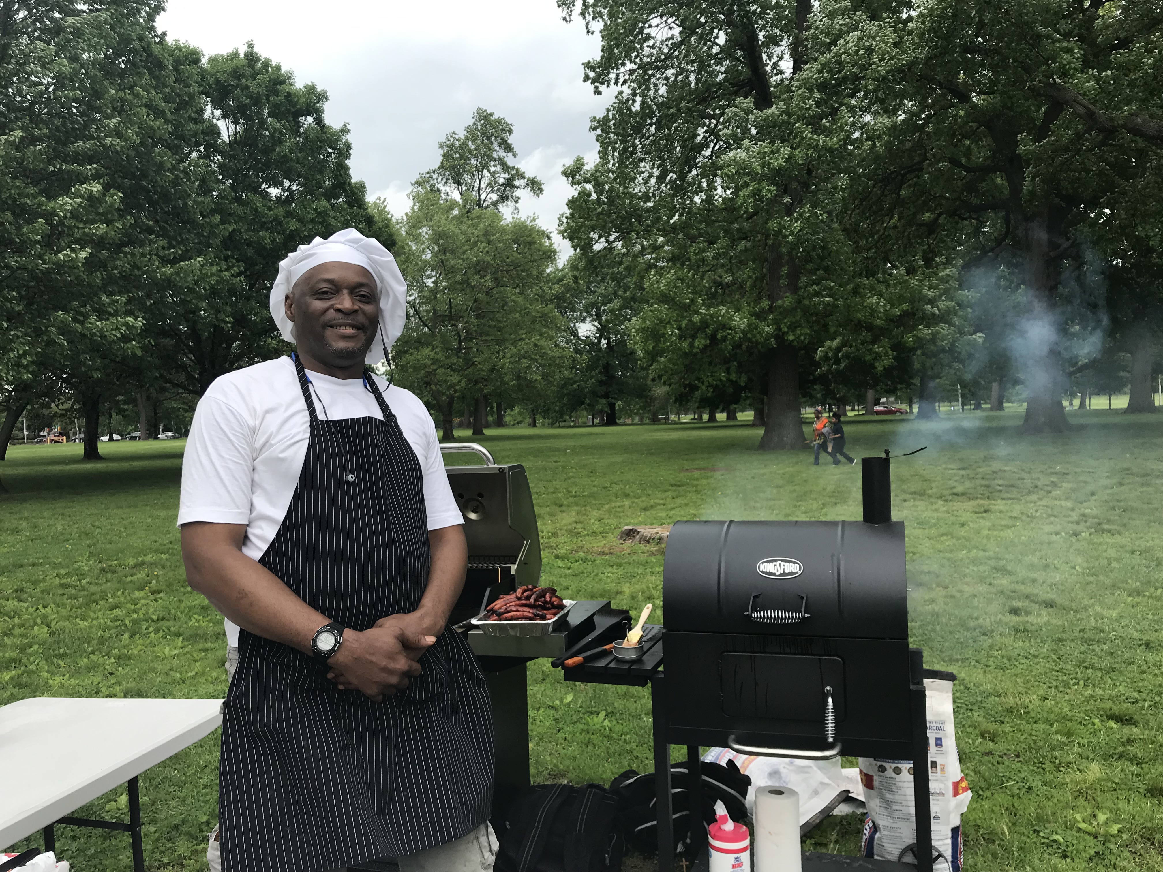 anthony at the cookout with grills behind him