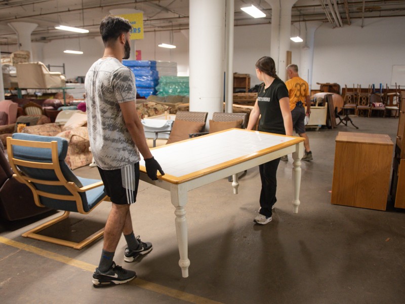 two volunteers carrying a table at PFB