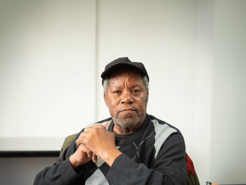 participant looking at the camera with hands clasped together in front of him