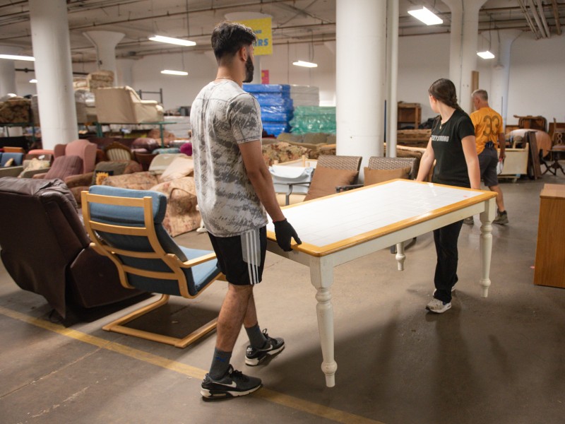 two volunteers carrying a table at PFB