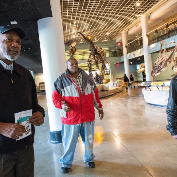 three people at a museum