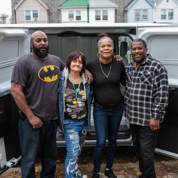 People hugging and smiling in from of moving van