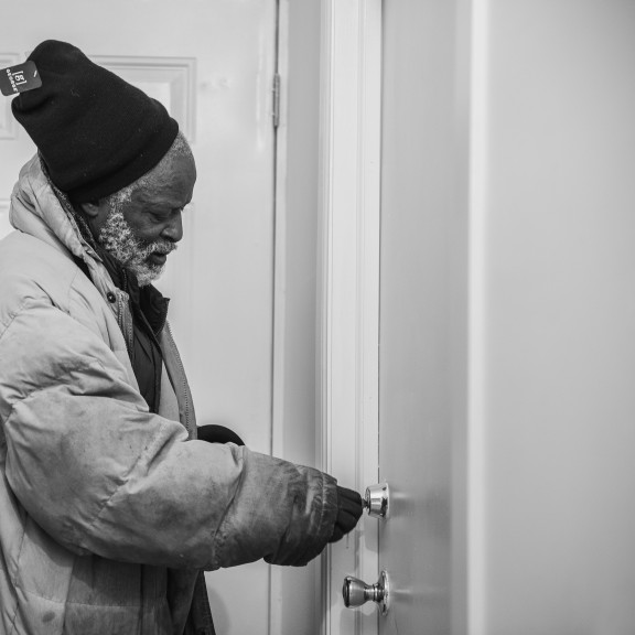 man using key to open door