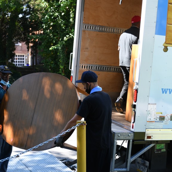 two men loading a table into a truck