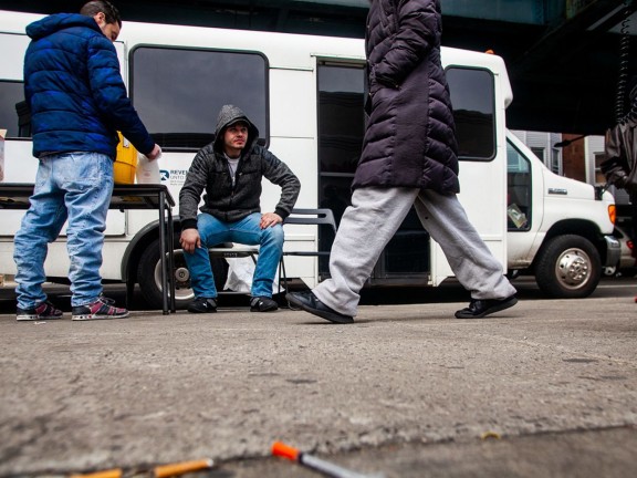 several people standing outside a mobile healthcare bus