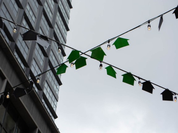 cutouts of houses hanging from a string of lights