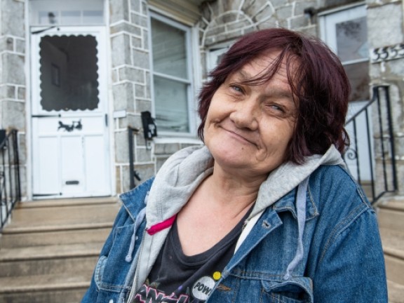 woman smiling in front of her home