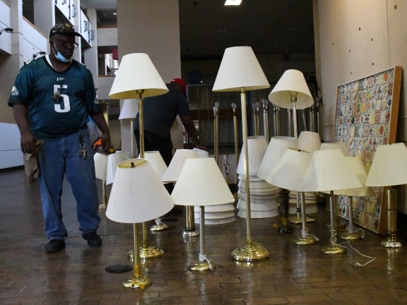 man standing next to several lamps