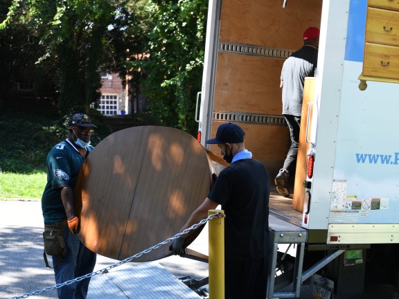 two men loading a table into a truck