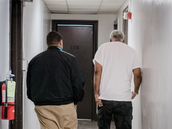 home visit, two men walking in a hallway
