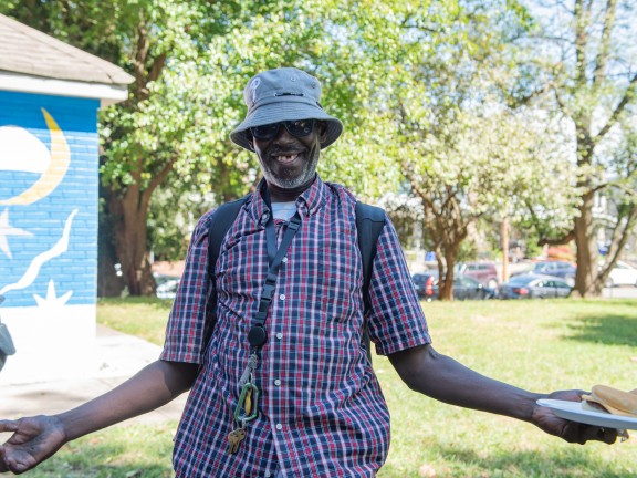 participant smiling with hands open at our annual cookout