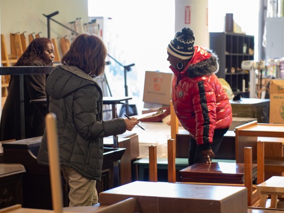 volunteer helping clients choose furniture