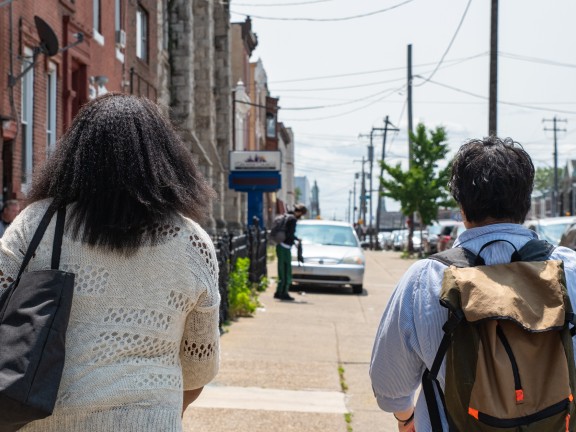 two people faced away from camera walking away down a philly street