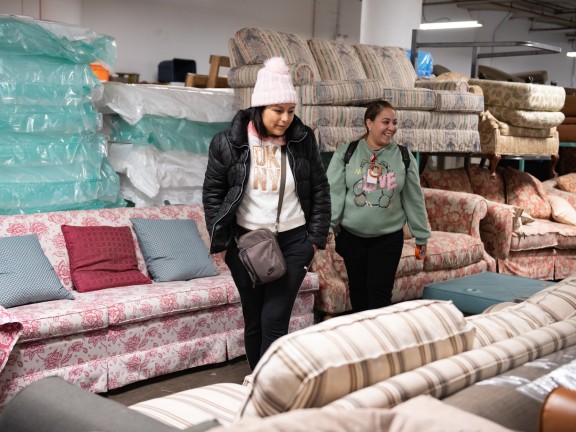 client and case manager in the furniture bank picking furniture near the sofas