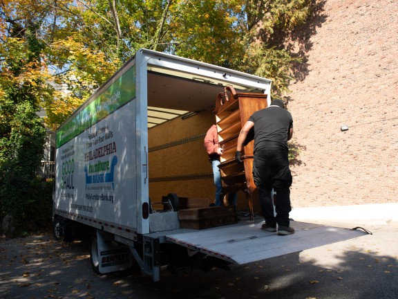 two good haul employees loading a dressed onto a midsize truck