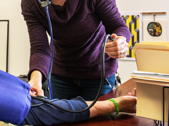 nurse taking participant blood pressure, faces are not in frame
