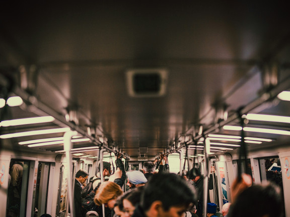 people, indistinct, on a subway train, mostly ceiling