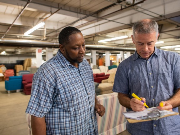 Two men looking at a clipboard