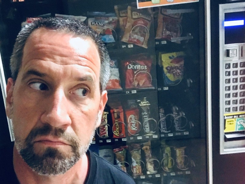 Jonas eyeing the Snickers in the snack machine