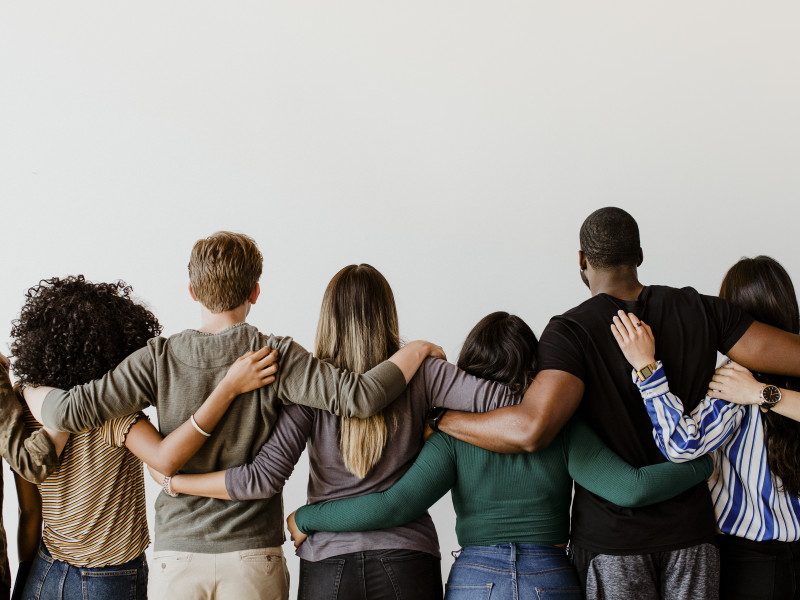 group of people hugging each other behind view