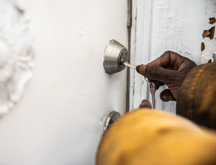 hand using key to open door