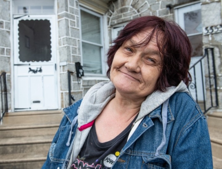 woman smiling in front of her home