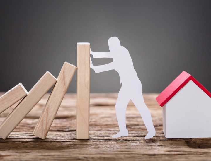man keeping building blocks from toppling over