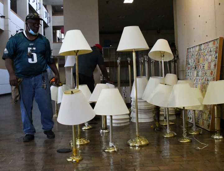 man standing next to several lamps