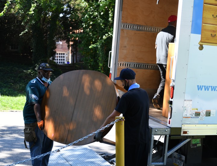 two men loading a table into a truck