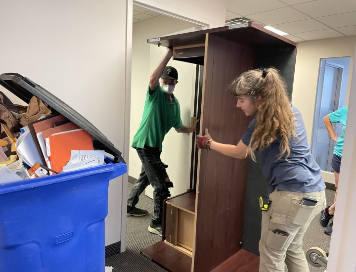 two people moving a desk
