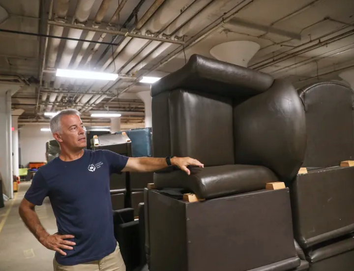PFB's Director standing next to chairs in the warehouse