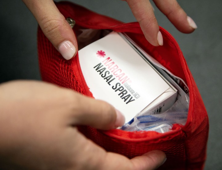 person opening an overdose reversal kit containing naxalone