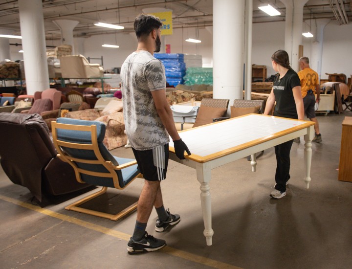 two volunteers carrying a table at PFB