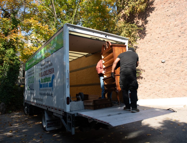 two good haul employees loading a dressed onto a midsize truck