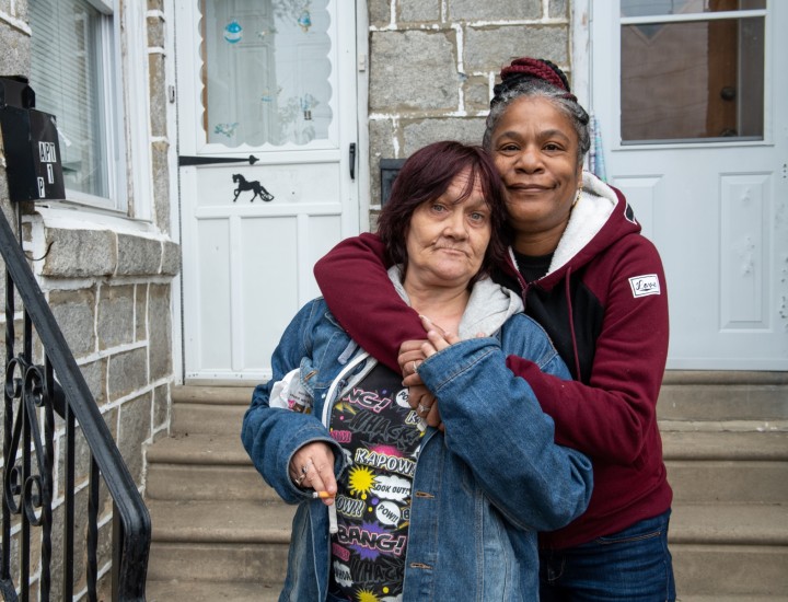 two participants in front of their home 
