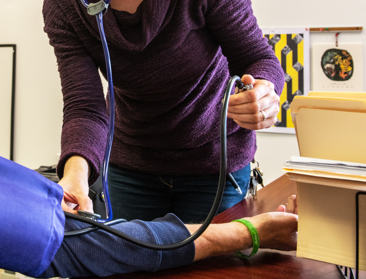 nurse taking participant blood pressure, faces are not in frame