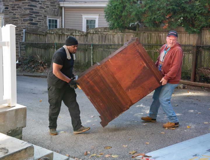 two movers hauling a dresser
