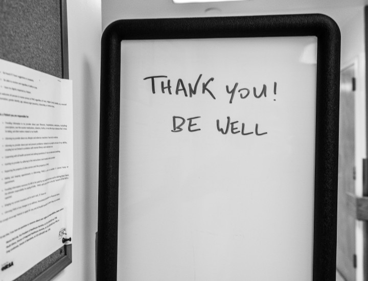 whiteboard on an office door that reads "Thank you! Be well"